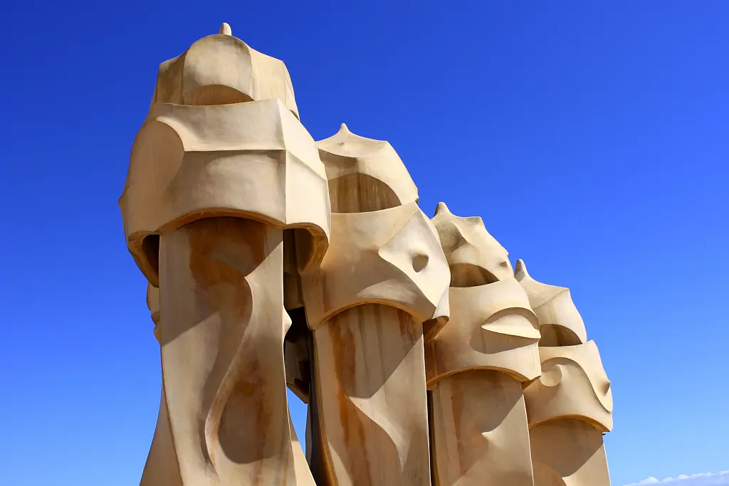 4 sand-coloured chimneys clad with stone looking like knights with helmets